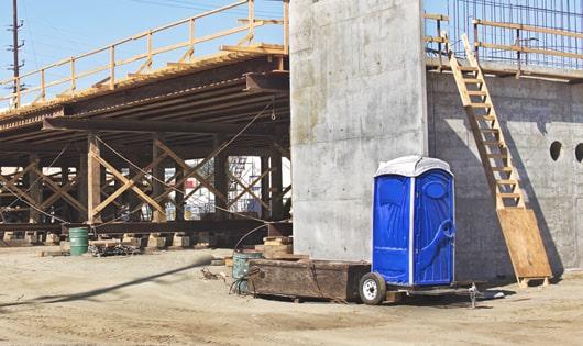 a row of blue portable toilets set up on a construction site